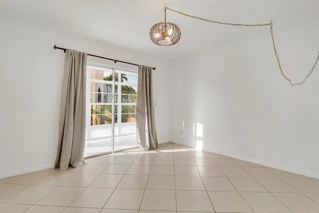 an empty room with chandelier fan