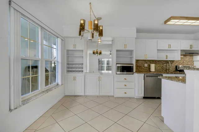 a kitchen with white cabinets and white appliances