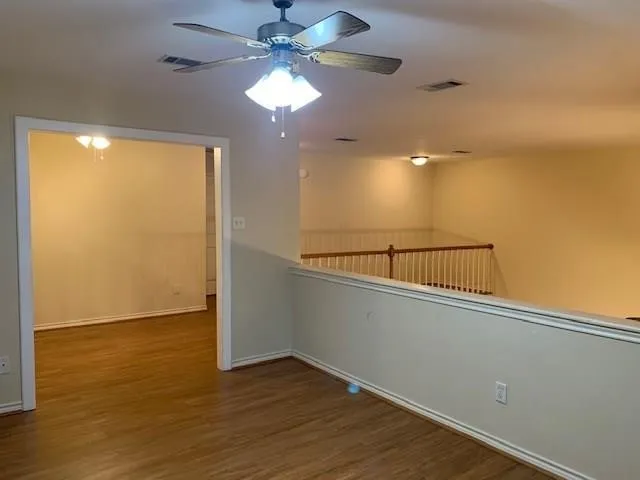 a view of a room with wooden floor and fan