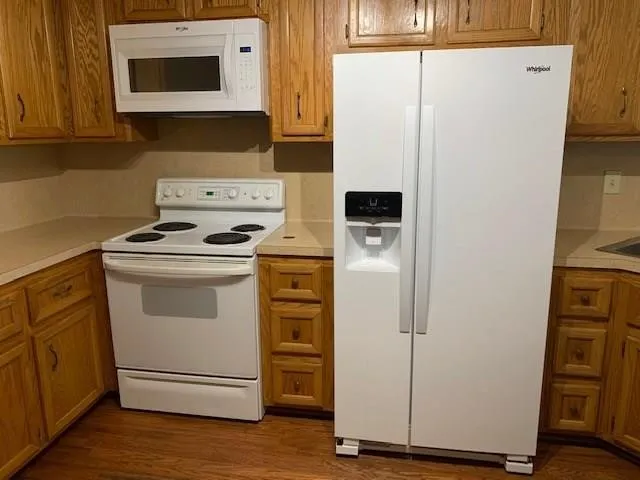 a white refrigerator freezer and a stove sitting inside of a kitchen