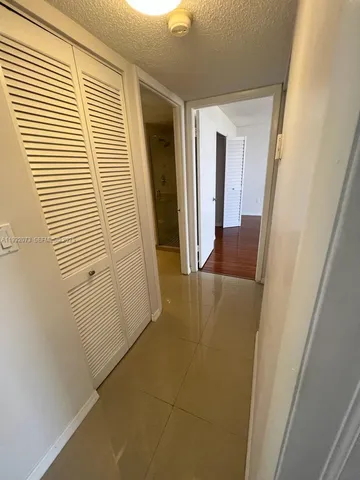 a view of an empty room with wooden floor and windows