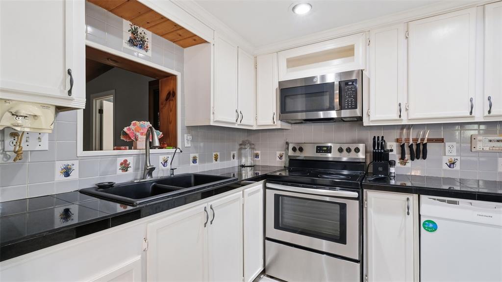10565 Bessemer Street New Port Richey, FL 34654 - Photo 3 of 72 a kitchen with stainless steel appliances granite countertop a sink stove and cabinets