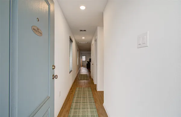 a view of a hallway with wooden floor