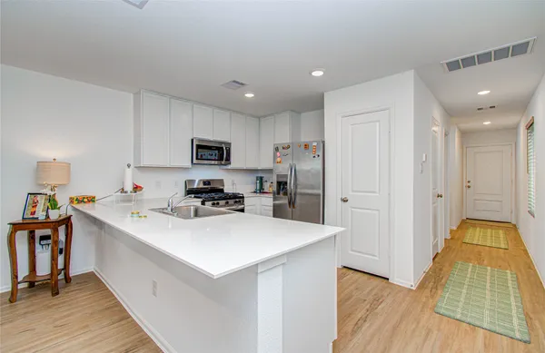a kitchen with a sink a counter top space stainless steel appliances and cabinets