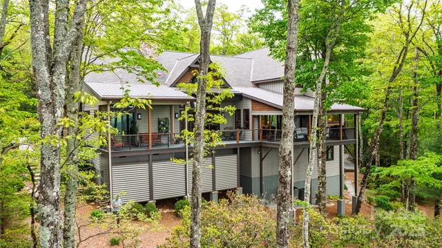 a view of a patio with table and chairs potted plants with wooden floor and floor to ceiling window