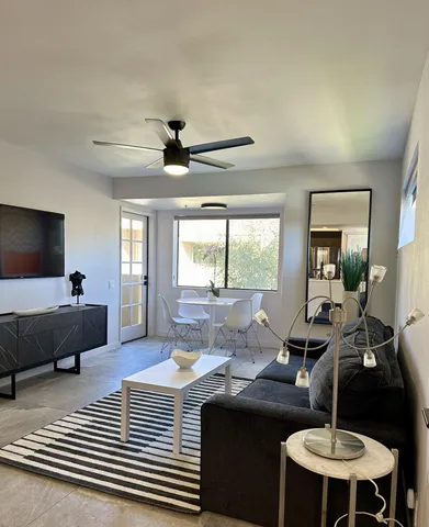 a living room with furniture a chandelier and a flat screen tv