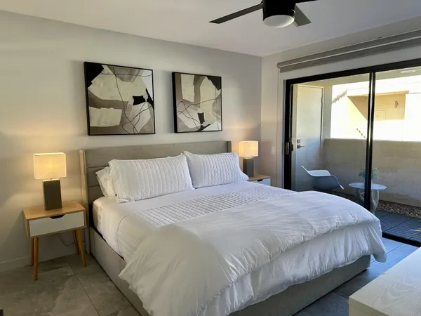 a bedroom with a large bed and a painting on the wall