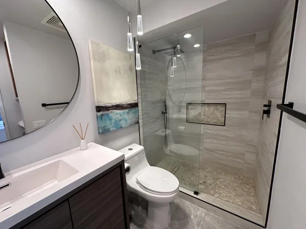 a bathroom with a sink a toilet and shower