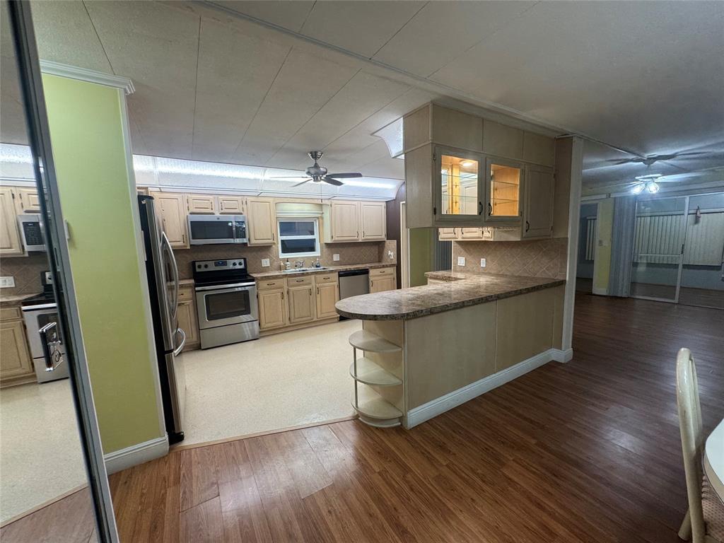 1921 Southwest 83rd Avenue Davie, FL 33324 - Photo 11 of 30 a kitchen with stainless steel appliances kitchen island wooden floors wooden cabinets and entryway