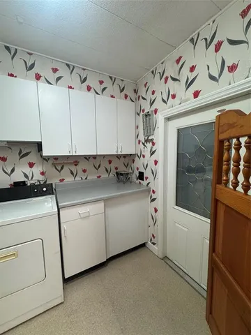a utility room with cabinets washer and dryer