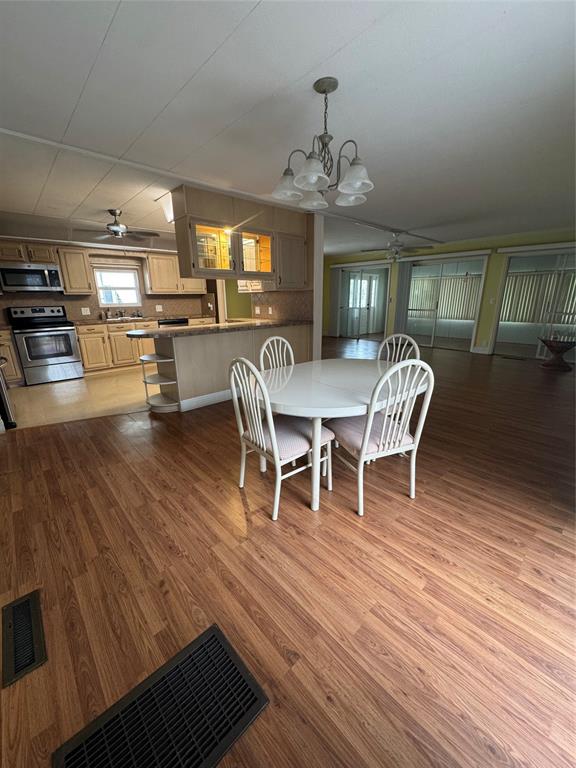 1921 Southwest 83rd Avenue Davie, FL 33324 - Photo 17 of 30 a dining room with wooden floor a chandelier a wooden table and chairs