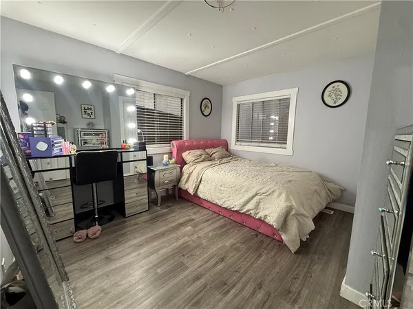 a bedroom with a bed window with table and chair