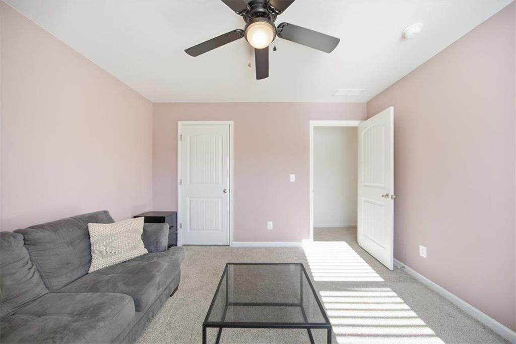 7946 Hansell Court Lithia Springs, GA 30122 - Photo 40 of 58 a living room with furniture and a chandelier