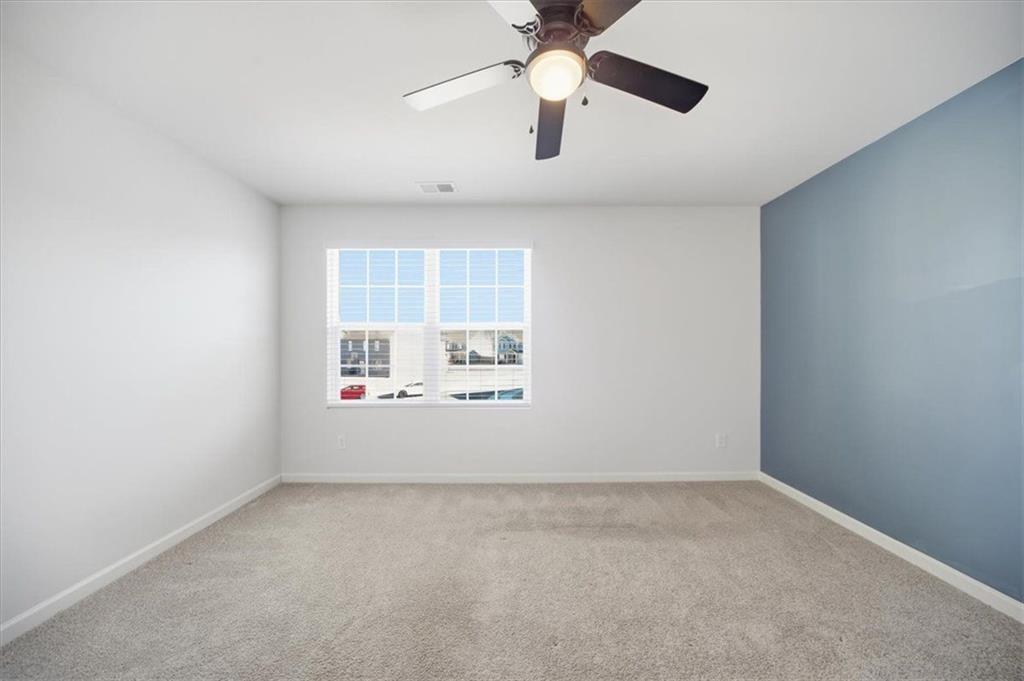 7946 Hansell Court Lithia Springs, GA 30122 - Photo 43 of 58 an empty room with windows and chandelier fan