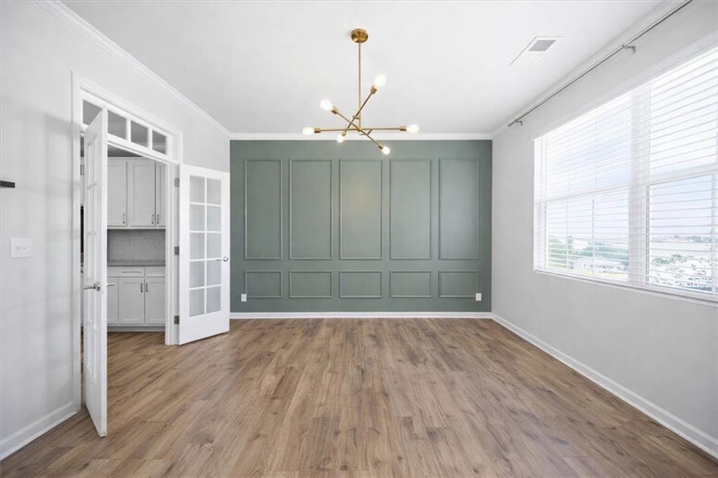 7946 Hansell Court Lithia Springs, GA 30122 - Photo 7 of 58 an empty room with wooden floor chandelier fan and windows