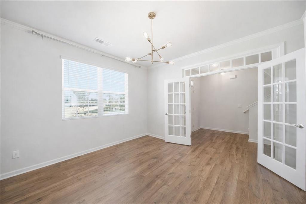 7946 Hansell Court Lithia Springs, GA 30122 - Photo 8 of 58 an empty room with wooden floor cabinet and windows