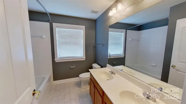 a en suite bathroom with a bathtub sink and mirror