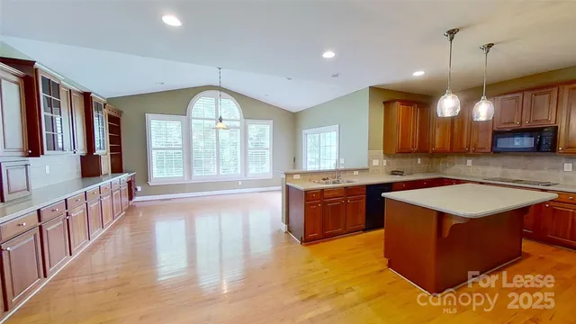 a large kitchen with kitchen island a large island in it