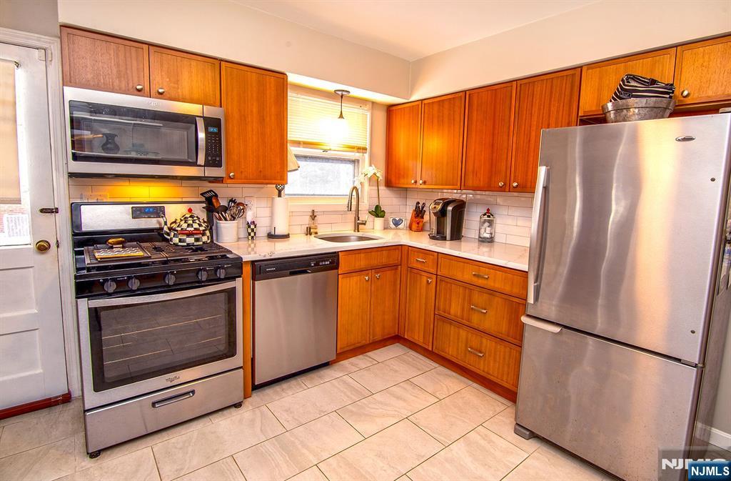 314 Valley Road Haworth, NJ 07641 - Photo 5 of 15 a kitchen with a refrigerator sink and microwave