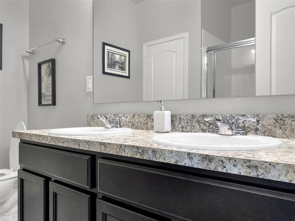 4548 Orchard Grove Road St. Cloud, FL 34772 - Photo 11 of 18 a bathroom with a granite countertop sink and a mirror