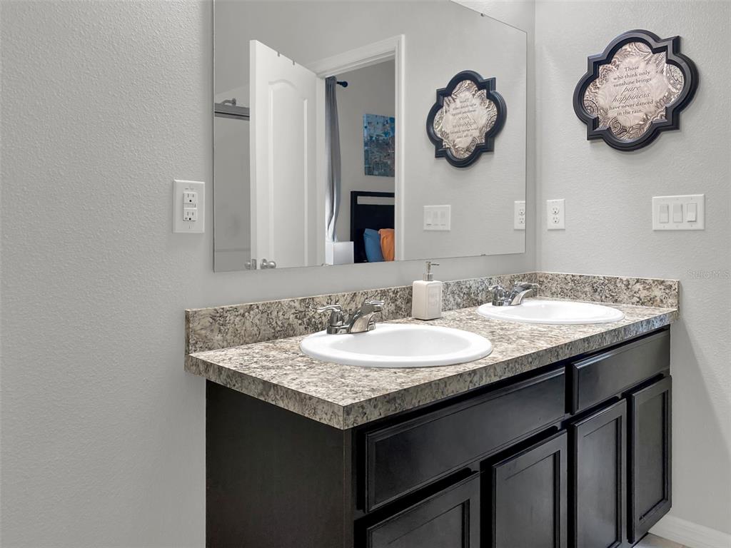 4548 Orchard Grove Road St. Cloud, FL 34772 - Photo 10 of 18 a bathroom with a granite countertop sink and a mirror