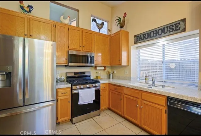 a kitchen with stainless steel appliances granite countertop a stove a sink dishwasher a refrigerator and a microwave