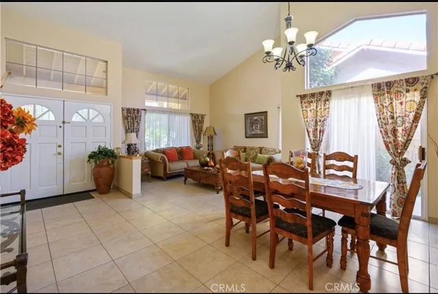 a living room with furniture a chandelier and a dining table