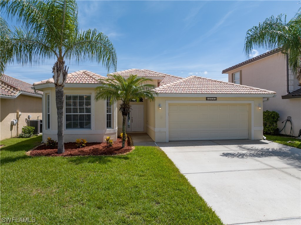 12713 Stone Tower Loop Fort Myers, FL 33913 - Photo 1 of 44 a front view of a house with a garden and trees