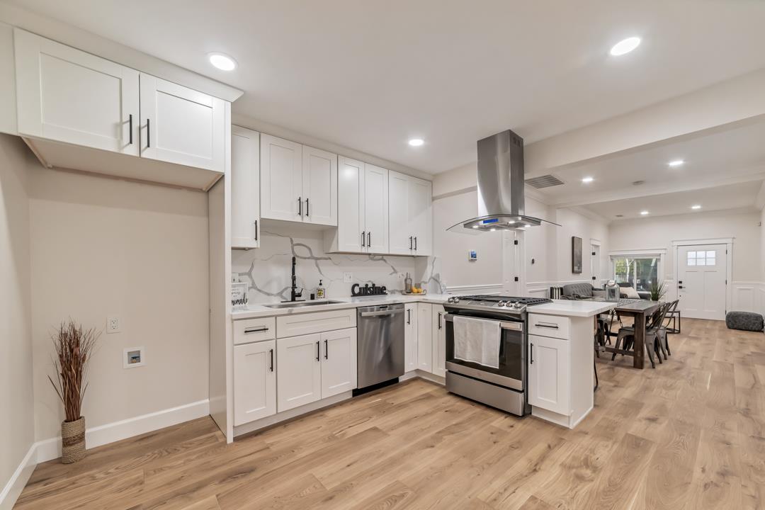 a kitchen with stainless steel appliances a stove a sink and a refrigerator