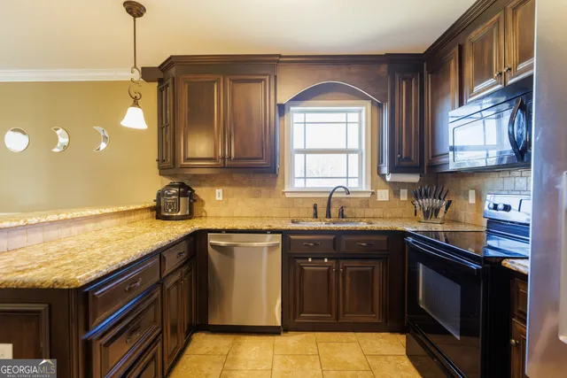 a kitchen with stainless steel appliances granite countertop a sink stove and cabinets
