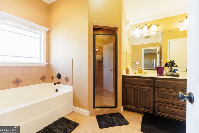 a bathroom with a tub sink and mirror
