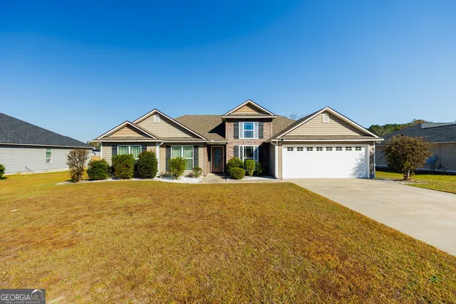 a front view of a house with yard and parking