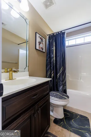 a bathroom with a sink a toilet a mirror and shower