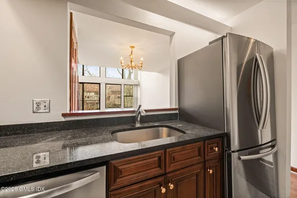 a kitchen with granite countertop a refrigerator and a sink