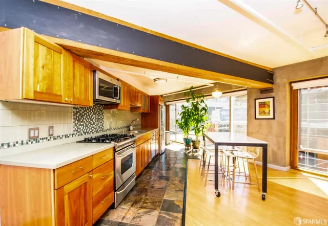 a kitchen with stainless steel appliances granite countertop a stove a sink and a microwave