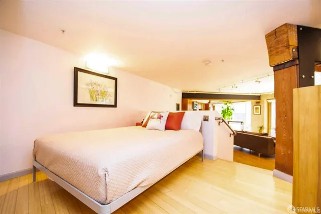 a bedroom with a bed and wooden floor