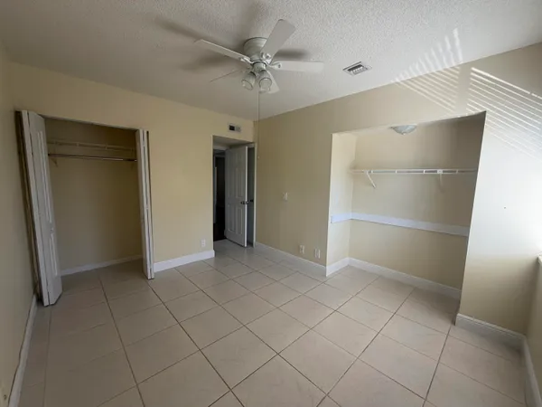 a view of an empty room with a ceiling fan