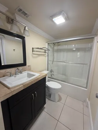 a bathroom with a toilet a sink a mirror and vanity