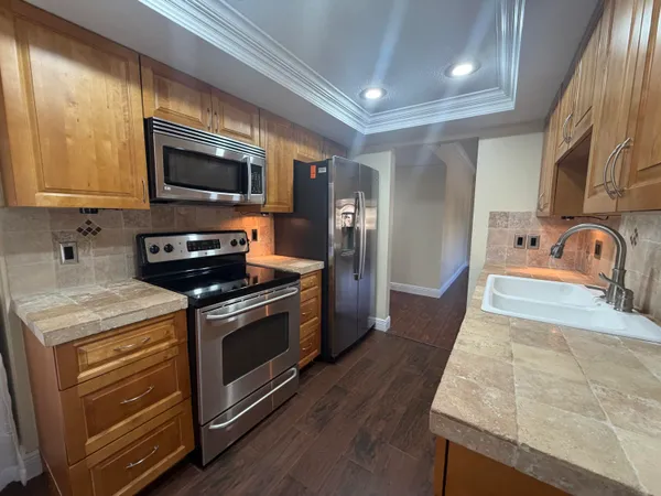 a kitchen with stainless steel appliances granite countertop a sink stove and microwave