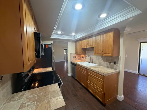a large kitchen with stainless steel appliances granite countertop a large counter top a stove and a refrigerator