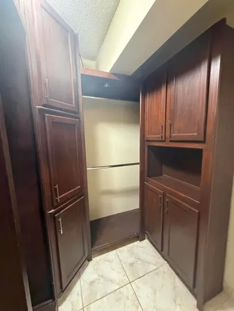 a view of kitchen with cabinets and refrigerator