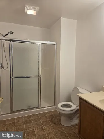 a white toilet sitting next to a shower