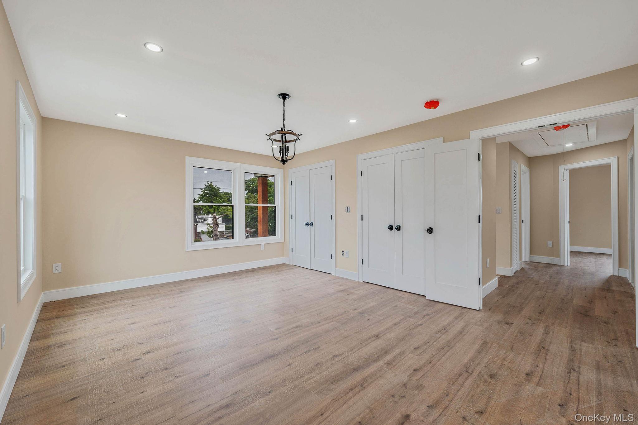 87 Sobro Avenue Valley Stream, NY 11580 - Photo 15 of 20 a view of an empty room with wooden floor and a window