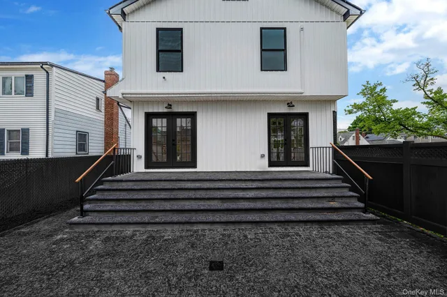 a view of a house with a large windows and flower plants