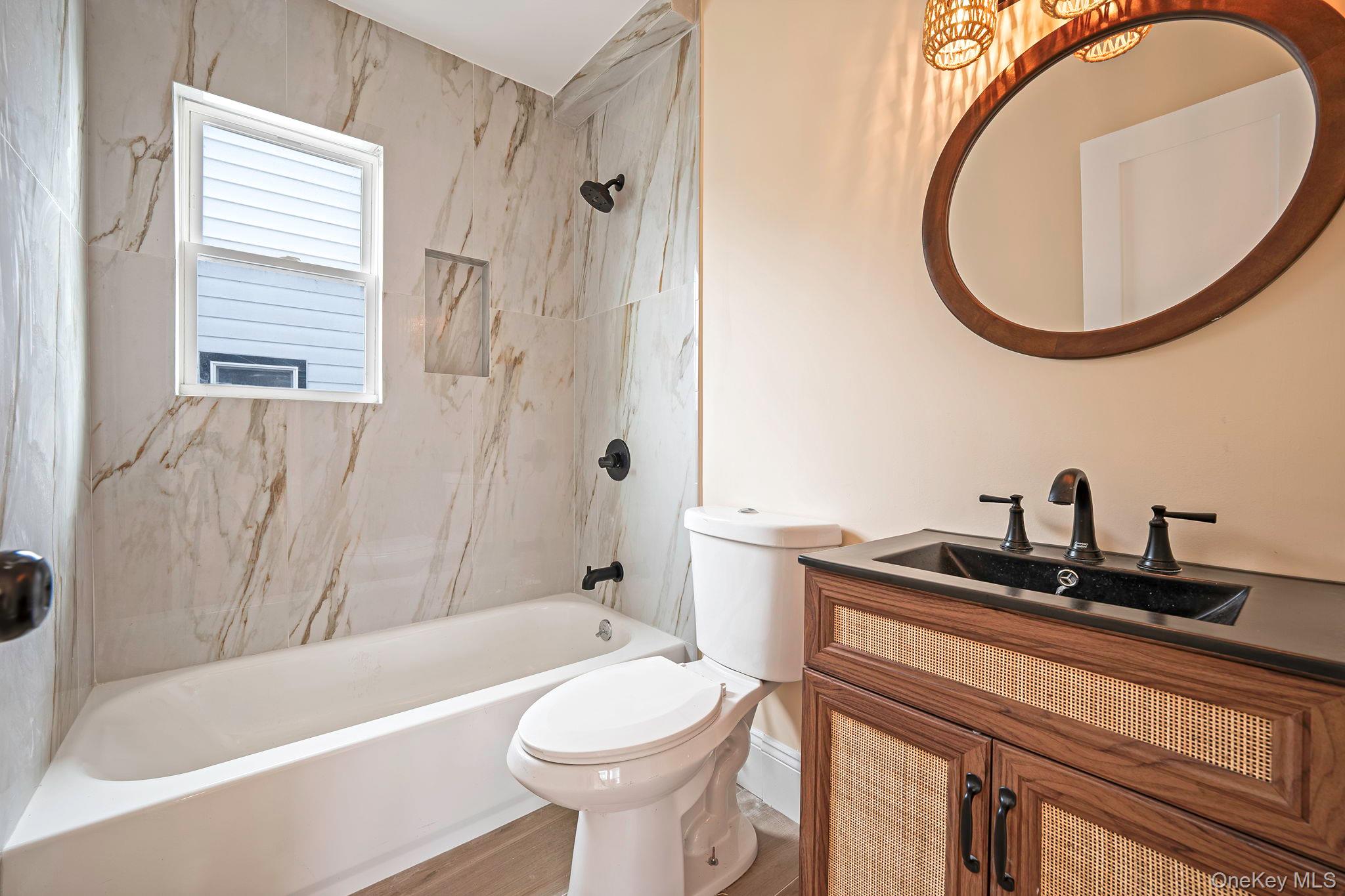 87 Sobro Avenue Valley Stream, NY 11580 - Photo 7 of 20 a bathroom with a sink a toilet and a mirror