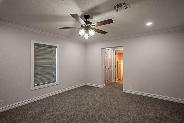 an empty room with windows and fan