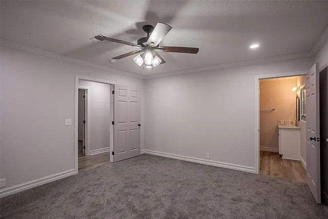 an empty room with closet and a ceiling fan