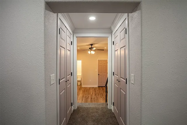 a view of a hallway with wooden shelves
