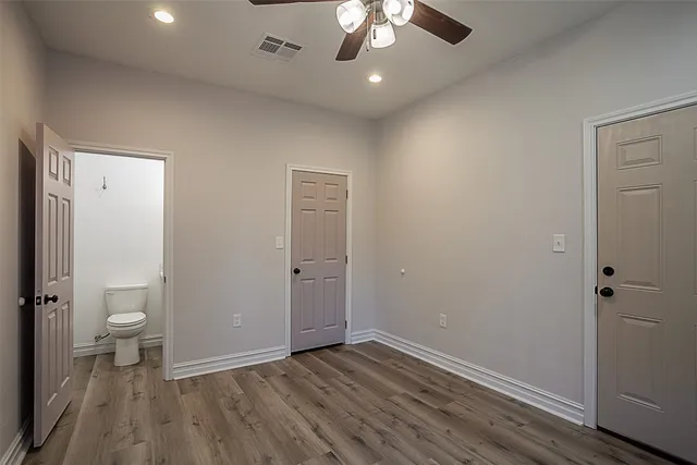 wooden floor in an empty room with a bathroom