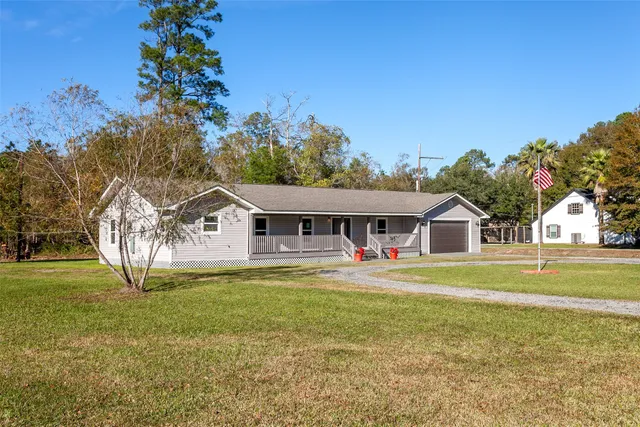 a front view of a house with a garden and trees